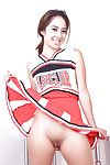 Oriental infant Mila Jade exposing smooth uterus beneath cheerleader outfit