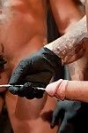 Alessio Romero leads Shane Frost to a table where an variety of sounding rods is laid out. Alessio squeezes a puddle of lube onto a tray, twirls the end of a surgical iron sound in it and demonstrates for Shane how to fuck your own cock. Shane watches whi