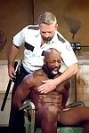 At a detention facility called The Center, Race Cooper is being interrogated by uniformed guard Dirk Caber, looking smoking sweaty with a salt-and-pepper beard and mustache. Race is stripped and chained to a chair. His muscles glisten with restless sweat.