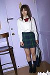 Sedutor Oriental infantil menina com Pequeno pantoons jolly fora ela escola uniforme