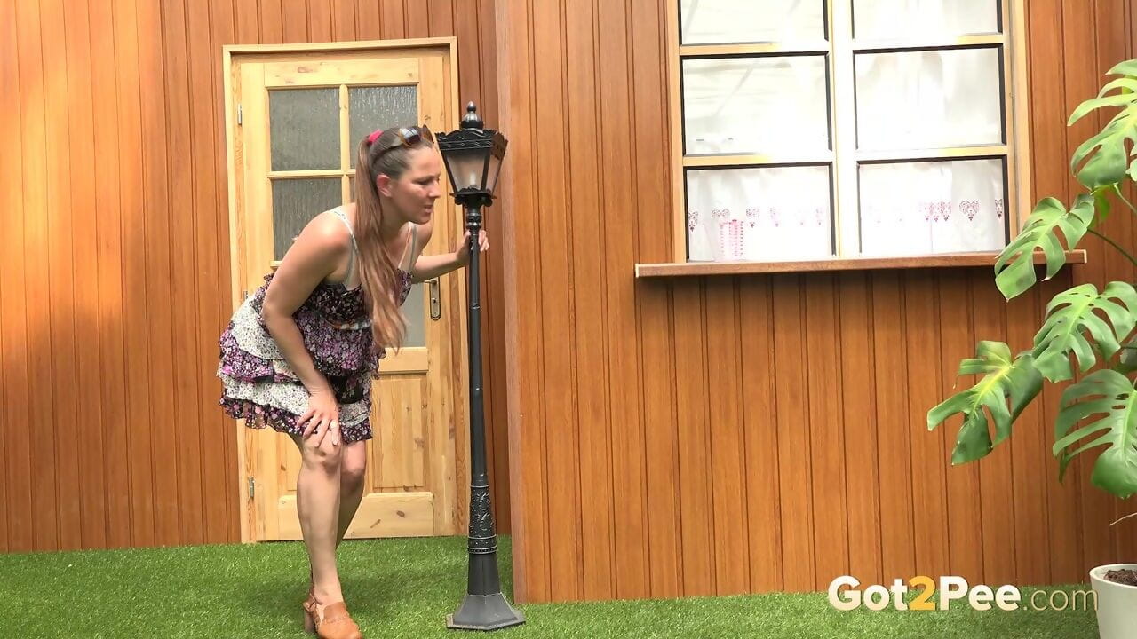 Blonde woman Nicol D hikes short dress to pee standing behind the house