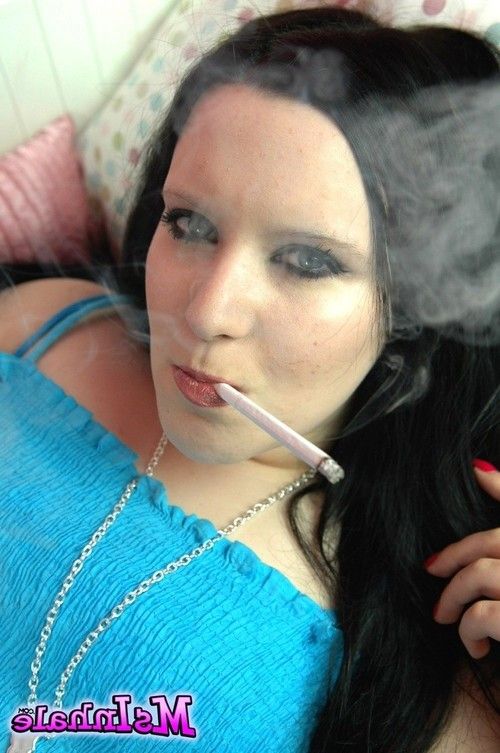 Naughty teen smoker rubs her pussy while she smokes a cigarette