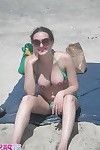 Busty brunette takes sunbath on public beach
