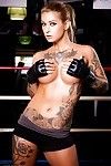 Tattooed MILF pornstar Kleio Valentien in shorts showing big tits in gym