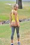 Sexy blonde girl shedding spandex pants and top to pose nude in public park