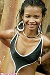 Cute thai brunette strips from her black bikini on the sea shore