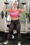 Playful blonde bodybuilder uncovering her curvy body in the gym