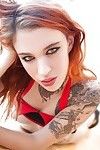 Tattooed redhead Mabel baring her perk tits and fingering her skinny twat