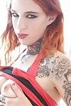 Tattooed redhead Mabel baring her perk tits and fingering her skinny twat