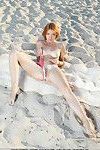 Redheaded teen babe revealing big tits and shaved pussy outdoors on beach