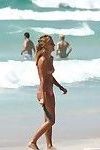 Voyeur shots of a cute topless girl playing at the beach