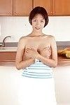 Clothed Asian with tiny tits is posing in the kitchen with spread legs