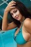 Bellezza Bruna in Blu bikini mostra Il suo Tette in il piscina