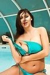 美 黑发 在 蓝色 比基尼 显示 她的 胸部 在 的 游泳池