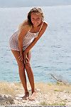 Solo girl Mango A modeling naked on rocky beach after disrobing