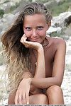 Solo girl Mango A modeling naked on rocky beach after disrobing