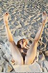 Redheaded teen babe revealing big tits and shaved pussy outdoors on beach