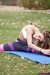 yoga entusiasta de la Kara faux quita su Ropa en su yoga mat fuera en el césped