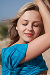 natuurlijke Blond meisje houdingen in De Buff op een wind geveegd Strand