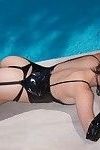 Sierlijke hottie poseren in sexy latex en nylon Outfit in De zwembad