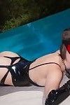 Elegante hottie posando en sexy látex y nylon Traje en el junto a la piscina