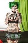Glasses attired punker Sydnee Vicious showing off tattoos in pleated skirt