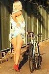 ผู้หญิง กับ bleached ผมบลอนด์ Mullet ขี่ม้า ขี่จักรยาน กับ pantyless รอบๆ เมืองนี้