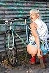 Girl with bleached blonde mullet riding bike with pantyless around town