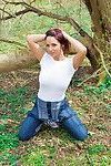 Stunning redhead babe Nikki removes her tight shirt in the woods