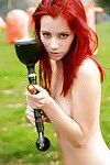 Stunning teen redhead Piper posing naked with a paintball gun