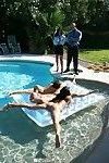 hai hotties trong bikinis đưa ra trong một hoang dã ba người tại những Bể bơi