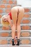 Stunning blonde teen strips off clingy red skirt to pose nude on stairs