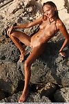 Erotic girl Mango A with perky tits showing off wet shaved pussy on beach