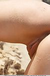 teen Modell Caprice ein Schalen der Badeanzug auf sandy Strand zu anzeigen getrimmt Twat